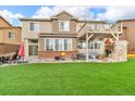 Spacious backyard with lush artificial grass, patio area, and a two-story deck at 3745 Spanish Oaks Trl, Castle Rock, CO 80108