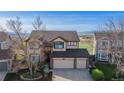 Aerial view of the two-story home situated on a large lot with mountain views at 9586 W Victoria Dr, Littleton, CO 80128