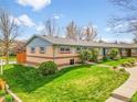 Beautifully landscaped townhome exterior with lush green grass, a front yard, and a walkway at 4201 Shoshone St, Denver, CO 80211