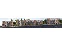 Long view of the side of a newly built apartment building complex on a tree-lined street at 1634 N Sheridan Blvd # 106, Denver, CO 80204