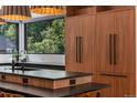 Kitchen island with a black countertop, wood cabinets, and stainless steel appliances at 6123 Buffalo Run, Littleton, CO 80125