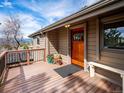Inviting entrance with wood door, adjacent bench, and potted plants add to the exterior's appeal at 24172 Jerome Ct, Golden, CO 80401