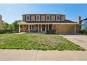 Charming two-story home with a brick and tan facade, solar panels, and a covered front porch at 3285 W 11Th Avenue Ct, Broomfield, CO 80020