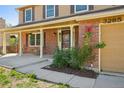 Close-up of the covered front porch with brick columns and a view of the front door at 3285 W 11Th Avenue Ct, Broomfield, CO 80020
