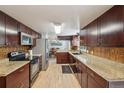 Well-lit kitchen featuring granite countertops, stainless steel appliances, and wooden floors at 3285 W 11Th Avenue Ct, Broomfield, CO 80020
