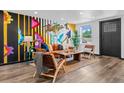 Modern living room featuring a vibrant mural, wood floors, and ample natural light at 3275 W Hawthorne Pl, Denver, CO 80221