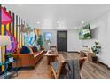 Bright living room with hardwood floors, funky wall art, and contemporary decor at 3275 W Hawthorne Pl, Denver, CO 80221