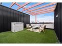 Inviting rooftop patio with artificial turf, lounge furniture, and a pergola, perfect for relaxing and enjoying the outdoors at 3040 Wilson Ct # 2, Denver, CO 80205