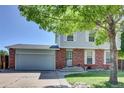 Exterior elevation of home with attached garage, brick facade, and gray siding, showcasing curb appeal at 17825 E Carolina Pl, Aurora, CO 80017
