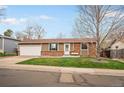 Charming single-story home featuring a well-maintained lawn, a two-car garage, and classic brick accents at 3308 E 118Th Way, Thornton, CO 80233