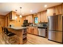 Well-lit kitchen features light wood cabinets, stainless steel appliances, and a granite countertop island with bar seating at 446 Blue River Rd, Breckenridge, CO 80424