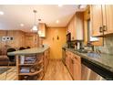 Well-lit kitchen features light wood cabinets, stainless steel appliances, and a granite countertop island with shelving at 446 Blue River Rd, Breckenridge, CO 80424