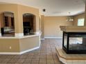 Open-concept living room showcases a fireplace, tile flooring, breakfast bar, and views of the kitchen and dining area at 20787 E 39Th Ave, Denver, CO 80249
