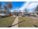 Home with covered front porch and walkway; yard enclosed by chain link fence at 1947 Jay St, Lakewood, CO 80214