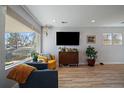 Cozy living room with large windows, stylish furniture, and wood-look floors at 1947 Jay St, Lakewood, CO 80214
