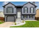 Beautiful two-story home with gray siding, black shutters, and well manicured lawn offering great curb appeal at 19661 E Girard Ave, Aurora, CO 80013