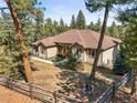 Aerial view showcasing a well-maintained home with a manicured lawn amidst a serene forest backdrop at 20957 Horse Bit Way, Morrison, CO 80465
