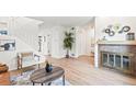 Living room with fireplace, wood floors, staircase, and neutral decor at 10311 E Evans Ave # 132, Aurora, CO 80247