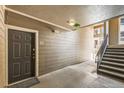Hallway entrance with exterior door, wood paneled walls, and stairway to upper floors at 2855 Blue Sky Cir # 3-102, Erie, CO 80516