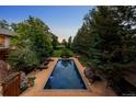 Beautiful backyard with a large swimming pool, patio, and lush landscaping at 850 E Radcliff Ave, Cherry Hills Village, CO 80113