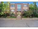 Exterior view of building with brick facade, large windows, and landscaped entryway at 1144 N Ogden St # 304, Denver, CO 80218