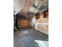 Spacious garage with a wooden door, concrete floors and storage shelves at 13430 Green Cir, Broomfield, CO 80020
