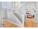 Bright foyer with hardwood floors, a staircase with white railings, and views into the living room at 11687 Newton St, Westminster, CO 80031