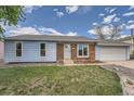 Charming home featuring blue siding, brick accents, lush green lawn, and a welcoming front entrance at 17731 E Bails Pl, Aurora, CO 80017