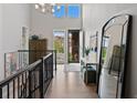 Bright entryway with hardwood floors, modern lighting, and decorative mirror reflecting natural light at 5608 Raintree Dr, Parker, CO 80134