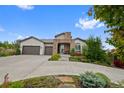 Charming home with a stone-accented entrance, 2-car garage, and well-maintained landscaping at 5608 Raintree Dr, Parker, CO 80134