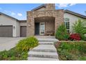 Charming home with a stone-accented entrance, steps to the door, and well-maintained landscaping at 5608 Raintree Dr, Parker, CO 80134