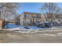 Multi-unit townhouse complex showcases exterior stairs, balconies, and snow-covered landscaping on a sunny day at 6021 Yarrow St # B13, Arvada, CO 80004
