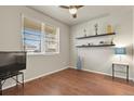 Cozy bedroom is equipped with hardwood floors, a ceiling fan, and a window with blinds at 9235 Quintero St, Commerce City, CO 80022