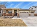 Charming home boasts a three car garage, stone accents and a covered porch with well-manicured landscaping at 9235 Quintero St, Commerce City, CO 80022