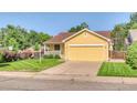 Inviting yellow home featuring a spacious two-car garage and a well-manicured front lawn at 3100 S Corona St, Englewood, CO 80113