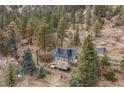 Aerial view of mountain home with wooded surroundings, unique architecture, and private setting at 1264 Beaver Brook Canyon Rd, Evergreen, CO 80439