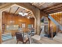 Inviting dining area with wood-paneled walls and ceilings, modern lighting, and glass-top dining table at 1264 Beaver Brook Canyon Rd, Evergreen, CO 80439
