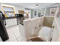 Bright kitchen featuring white cabinetry, tile floor, and an adjacent staircase at 6013 S Logan St, Centennial, CO 80121