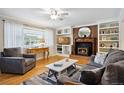 Comfortable living room showcasing a brick fireplace, built-in shelving, and hardwood floors at 6013 S Logan St, Centennial, CO 80121