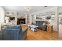Open-concept living area with hardwood floors, fireplace, built-in shelves and kitchen access at 6013 S Logan St, Centennial, CO 80121