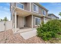 Inviting front porch with beige siding and rock ground cover and a front door with storm door at 19047 Randolph Pl, Denver, CO 80249