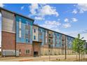 Multi-story apartment building showcasing a blend of brick and blue siding with individual garage parking and balconies at 487 Interlocken Blvd # 303, Broomfield, CO 80021