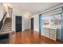 Entryway with hardwood floors, staircase, and a dark-colored interior door at 11455 River Run Pkwy, Commerce City, CO 80640