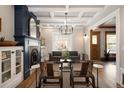 Sun-drenched living room with detailed fireplace, hardwood floors, and modern chandelier at 1050 N Clarkson St, Denver, CO 80218