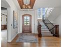 Grand foyer with hardwood floors, wood ceiling accents, staircase, and a decorative chandelier at 1039 Buffalo Ridge Way, Castle Pines, CO 80108