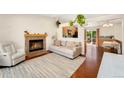 Bright living room featuring a fireplace, hardwood floors, and seamless flow to the outdoor patio at 9376 W Wagon Trail Cir, Littleton, CO 80123