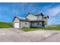 View of two-story home with gray siding, dark blue accents and a front yard at 43793 Buckskin Rd, Parker, CO 80138