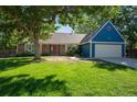 Charming ranch home with blue siding, red front door, and lush green lawn at 3824 S Xenia St, Denver, CO 80237