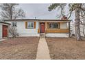 Close-up of a single-story home with a bright red front door and wood detail at 3361 S Dahlia St, Denver, CO 80222