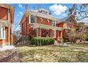 Charming red brick two-story home with manicured lawn and mature trees at 1346 Steele St, Denver, CO 80206